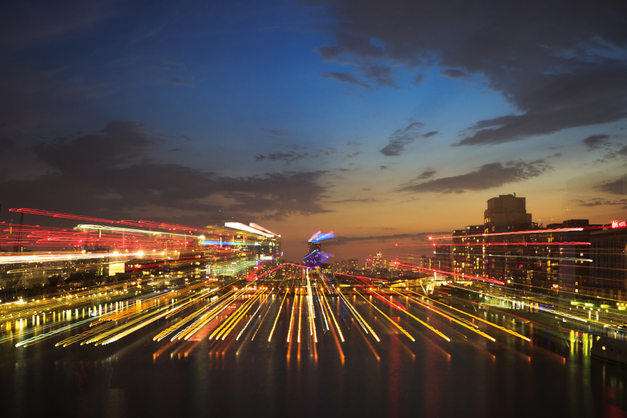 Aerial view of traffic in roundabout and highway at night.